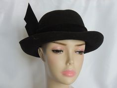 "Please measure your head prior to ordering to be sure this hat will fit. There are no returns. Fun black wool felt fedora style women's dress hat featuring a black velvet hat band with a decorative black wool felt bow on the right side. Label reads \"Designed by Sylvia, New York, St. Louis\". Interior circumference measures 21 1/4\". Lightly soiled but otherwise in Great Condition" Fitted Fedora With Curved Brim For Evening, Fitted Black Brimmed Costume Hats, Fitted Cloche Hat For Winter Evenings, Fitted Cloche Hat For Evening In Winter, Classic Fitted Fedora For Evening, Evening Fedora With Short Brim And Fitted Design, Black Hat Bands For Evening With Short Brim, Evening Fedora With Short Brim, Fitted Classic Evening Fedora