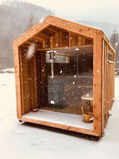 a sauna in the snow with its doors open to show it's surroundings