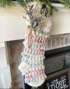 a crocheted christmas stocking hanging from a mantel above a fire place