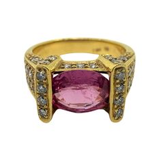 This 18k gold ring is a striking piece for any jewelry collection. Featuring a 1.87 carat oval pink sapphire and 0.63 carat round white diamond accents, it showcases a modern design.  18k Gold Pink Sapphire and Diamond Ring   Condition: In good condition with some minor surface wear consistent with age.   Ring size: 6.25   Total Weight: 7.64 grams   Diamonds: 0.63 carat Pink Sapphire: 1.87 carat Designer Oval Gemstone Rings, Formal Oval Ruby Ring With Single Cut Diamonds, Oval Pink Sapphire Diamond Ring With Accents, Formal Pink Sapphire Ring In Yellow Gold, Formal Gold Sapphire Ring With Pink Sapphire, Formal Pink Sapphire Ring With Pave Setting, Formal Yellow Gold Pink Sapphire Ring, Yellow Gold Diamond Ring With Pink Sapphire Accents, Pink Oval Jewelry With Single Cut Diamonds