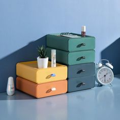 an assortment of colorful boxes with various items on them next to a clock and air freshener dispenser