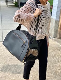 a woman carrying a black handbag on the sidewalk