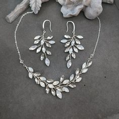 This listing is for a set of necklace and earrings.  Can be purchased separately: Earrings: https://www.etsy.com/listing/1453770349/boho-bridal-earrings-silver-vine?click_key=a7d05574172a32745f60d4c96cdaf730e1d5552e%3A1453770349&click_sum=d48575a2&ref=shop_home_recs_9&frs=1&sts=1 Necklace: https://www.etsy.com/listing/1445053778/boho-bridal-necklace-silver-vine?click_key=a6a7687761706fc8b203953fcb42eb295fd2f698%3A1445053778&click_sum=76200edf&ref=shop_home_active_2&frs=1&sts=1 Materials: white o Silver Crystal Jewelry With Matching Earrings, Costume Jewelry Crystal Sets With Matching Earrings, Crystal Costume Jewelry Sets With Matching Earrings, Silver Wedding Necklaces With Matching Earrings, Silver Necklaces With Matching Earrings For Wedding, Costume Jewelry Dangle Necklaces For Wedding, White Necklaces With Matching Earrings For Wedding, White Crystal Bridal Necklace With Matching Earrings, Elegant Silver Dangle Jewelry Sets