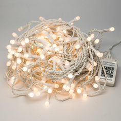 a string of white christmas lights on a white background with a q - code tag