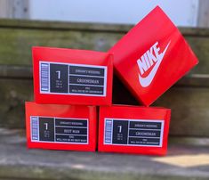 three red nike boxes sitting on top of a wooden bench