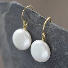 These earrings showcase AAA-grade, high-luster pearls that radiate pure sophistication. Each pearl, with its unique natural beauty, varies slightly in size, ranging between 12-14mm in a captivating coin shape. Adorned with delicate (but durable) gold-filled wires, these earrings effortlessly enhance the white pearls' inherent allure. We take pride in meticulously pairing each pearl to ensure a harmonious duo. Gift Pearl Earrings With French Hook, Gift 14k Gold Filled Pearl Earrings With Ear Wire, Delicate Pearl Earrings With Ear Wire, Delicate Hypoallergenic Round Pearl Earrings, Dainty Round Pearl Drop Earrings, Hypoallergenic Delicate Round Pearl Earrings, Minimalist Pearl White Pearl Earrings With Ear Wire, White Round Pearl Earrings In 14k Gold Filled, Dainty Pearl White Earrings With Ear Wire