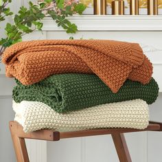 a stack of blankets sitting on top of a wooden chair