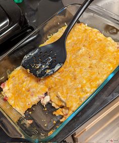 a casserole dish with chicken and cheese being gravy by a spatula