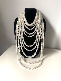 Stunning long multi-strand statement pearl necklace. Featuring a trendy layered chunky choker design. This cascade necklace showcases a beautiful waterfall of faux pearls in varying sizes, from delicate 2mm to bold 20mm. Perfect for adding a touch of elegance to any outfit, it's the ideal accessory for both casual and formal occasions. Make a statement with this eye-catching piece that effortlessly blends classic charm with modern flair. The necklace measures:  choker size 18" +4" (48 cm+10cm) Longest row : 46" (117 cm) Necklace drop: 23"(58cm) ----If you have any question please contact me---- I am inviting you to explore and enjoy my jewelry store; perhaps you will discover something unique for yourself or as a gift for someone special in your life. Thank you! https://www.etsy.com/shop/B Elegant Layered Long Necklace, Multi-strand Layered Pearl Necklace For Party, Multi-strand Layered Pearl Chain Necklace For Parties, Elegant Layered White Jewelry, Elegant Multi-strand Bib Necklace For Party, Elegant White Layered Choker Necklace, Elegant Beaded Pearl Layered Necklace, White Elegant Multi-strand Layered Necklace, Elegant White Multi-strand Layered Necklace