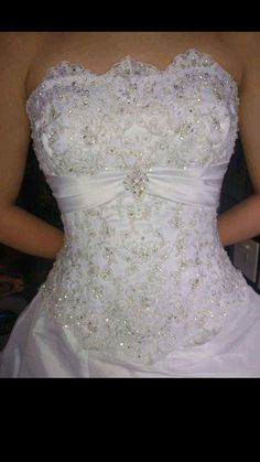 a woman wearing a white wedding dress with sequins on it