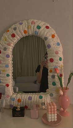 a woman taking a selfie in front of a decorated mirror