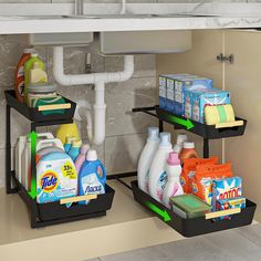 two black trays filled with cleaning products under a sink next to a faucet