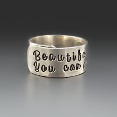 This Personalized Sterling Silver Wrap Ring, measures 3/8 inches in width. It is adjustable up to 1/2 size. Each piece is hand-stamped, creating a unique and personalized touch. Made from solid sterling silver, this ring is not only beautiful but also durable. It is the perfect accessory to showcase your individuality and can be customized with initials, a special date, or a meaningful word or short quote.  Whether you're treating yourself or looking for a heartfelt gift, this personalized ring is sure to be cherished for years to come. Return to my MAIN SHOP HERE: https://www.etsy.com/shop/StringOfJewels2 RING DETAILS: * Solid .925 sterling silver * 3/8 inches wide * This ring is not soldered closed * It is slightly adjustable up or down a half size. * If you are in between sizes order up Hand Stamped Sterling Silver Name Bracelet As Gift, Custom Text Engraved Silver Ring For Gift, Adjustable Sterling Silver Stamped Name Bracelet, Personalized Hand Stamped Silver Rings, Adjustable Silver Initial Ring Hand Stamped, Short Quote, Silver Wrap Ring, Personalized Ring, Sterling Silver Rings Bands