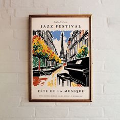 a poster hanging on the side of a white brick wall with a piano and eiffel tower in the background