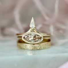 two gold wedding rings with a diamond on top