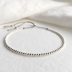 A beautiful dainty grey silk beaded bracelet with sterling silver beads and sliding clasp to adjust to your size. Looks great alone as a minimalist bracelet or can be stacked with other bracelets. Comes displayed in one of our pretty gift boxes, so fantastic as a present for a friend or to yourself! Shipping Uk: 2-3 days - Royal Mail 48hr tracked International standard delivery: 6- 14 days (delays can occur especially in busy periods) Please be aware that standard shipping is UNTRACKED and does not need to be signed for but you do have the option to upgrade to tracked and signed shipping (someone must be available to sign for the parcel on delivery) International orders over £50 will automatically be upgraded to tracked and signed shipping at no extra charge DETAILS - Grey silk cord - Ster Silver Adjustable Bracelets For Everyday Wear, Minimalist Silver Bracelet With Adjustable Length, Elegant Friendship Bracelets With Tiny Beads, Dainty Jewelry With Sliding Knot And Round Beads, Elegant Adjustable Beaded Bracelet With Silver Beads, Silver Jewelry With Sliding Knot For Everyday, Everyday Silver Jewelry With Sliding Knot, Elegant Adjustable Silver Beaded Bracelets, Elegant Adjustable Beaded Bracelet