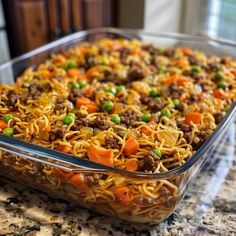 a casserole dish with noodles, meat and vegetables in it on a counter