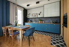 a kitchen with blue cabinets and wooden floors is pictured in this image from the dining room