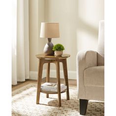 a small wooden table with a lamp on it in front of a chair and window