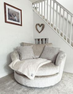 a living room with a round couch and stairs