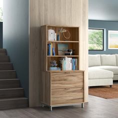 a living room scene with focus on the bookshelf and staircase leading to the upper floor