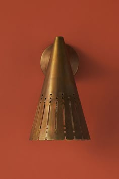 a wall mounted light on the side of a red wall