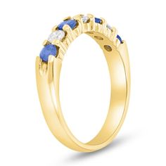 a yellow gold ring with three blue sapphire stones on the sides and two white diamonds in the middle