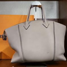 This Is An Authentic Louis Vuitton Veau Cachemire Soft Lockit Mm In Galet. This Stylish Tote Is Crafted Of Grained Cachemire Calfskin Leather In Grey-Beige. The Bag Features Rolled Leather Top Handles And A Removable, Adjustable Shoulder Strap With Silver Hardware. The Top Zipper Opens To A Suede Interior With Zipper And Patch Pockets. Grey Beige, Grey And Beige, Leather Top, Authentic Louis Vuitton, Silver Hardware, Womens Tote Bags, Patch Pocket, Calf Skin, Shoulder Strap