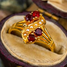 This charming antique ring features garnets and seed pearls and is crafted of 14k yellow gold. This ring is currently a size 3.75. Victorian Red Cluster Ring For Wedding, Victorian Style Red Cluster Wedding Ring, Vintage Gold Garnet Birthstone Ring, Vintage Yellow Gold Garnet Birthstone Ring, Vintage Garnet Birthstone Ring In Yellow Gold, Vintage Garnet Birthstone Ring For Wedding, Seed Pearl Ring, Antique Jewelry Rings, Antique Ring