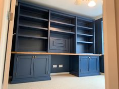 an empty room with blue bookcases and cabinets