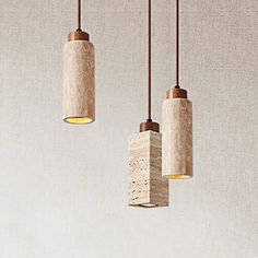 three light fixtures hanging from the ceiling in a room with beige walls and flooring