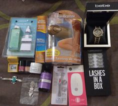 the contents of a woman's personal care kit are laid out on a bed