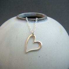 "small slanted heart necklace. sterling silver open heart. delicate dainty pendant. simple everyday modern jewelry. romantic special gift A small modern sterling silver slanted heart, paired with a simple chain, perfect special gift....for yourself or someone you love. - Sterling silver open heart, just over 1/2\" across (13 mm) at widest point.. - Necklace is solid sterling silver 1.5 mm cable chain, lobster clasp, and locking circle jump rings, all solid sterling silver. - Shiny finish, hangs Simple Open Heart Necklace For Anniversary, Simple Sterling Silver Heart Charm Necklace, Simple Open Heart Silver Jewelry, Simple Silver Open Heart Jewelry, Minimalist Open Heart Sterling Silver Necklaces, Simple Sterling Silver Heart Pendant Necklace, Simple Open Heart Necklace For Valentine's Day, Simple Sterling Silver Heart Necklace, Sterling Silver Open Heart Necklace For Valentine's Day