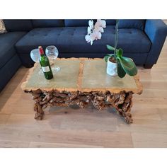 a coffee table made out of logs with vases and bottles sitting on top of it