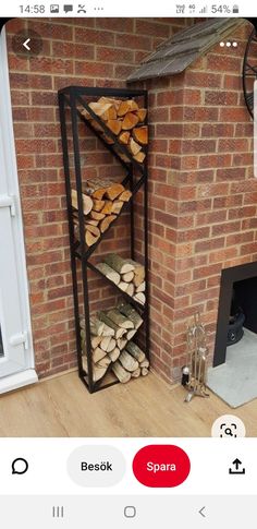 a stack of logs sitting in front of a brick wall next to a fire place