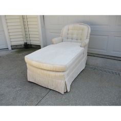 a white chair sitting in front of a garage door