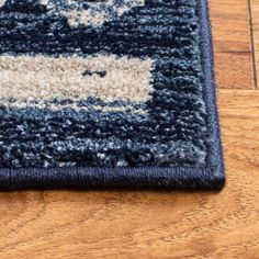 a blue and white rug on the floor with a wooden floor in front of it