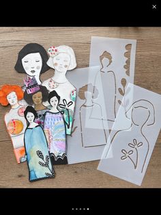 paper dolls and cut outs on a wooden table