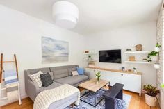 a living room filled with furniture and a flat screen tv mounted to the side of a wall