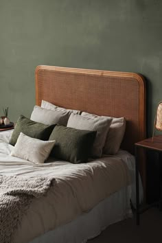 a bedroom with green walls and white bedding, two nightstands on either side