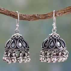 Neeru Goel crafts a delightful pair of jhumki which means hanging earrings in Hindi. The polished silver domes feature spherical dangles that suggest jingling bells. Diminutive sterling ropes add textural interest to these handcrafted fashion accessories. 0.925 Sterling silver Silver Jwellary, Desi Jewellery, Sterling Silver Flower Necklace, Oxidised Earrings, Silver Chandelier Earrings, Silver Flower Necklace, Silver Chandelier, Fair Trade Jewelry, Indian Jewellery Design Earrings