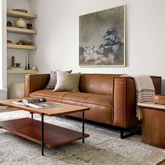 a living room filled with furniture and a large painting on the wall above the couch