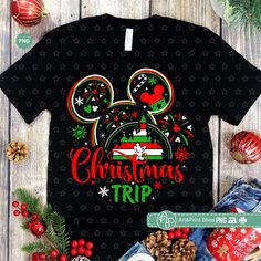 mickey mouse christmas trip t - shirt and other items on a wooden table with holiday decorations