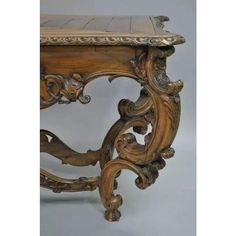 an ornately carved wooden table with marble top