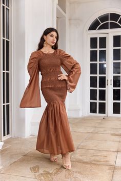 Introducing the Sienna Gown from Leah Anthoni, a stunning homage to the earth's natural beauty and the warmth of an autumn sunset. This gown is designed for the woman who carries the essence of elegance and grace in her every step. Crafted in luxurious, warm brown fabric, the Sienna Gown envelops you in comfort while exuding a sophisticated allure. The gown's unique texture and gentle flow pay tribute to the timeless beauty of the earth's layers, while its fitted bodice and flared skirt create a Elegant Brown Ruched Midi Dress, Elegant Brown Maxi Dress With Long Sleeves, Elegant Long Sleeve Brown Maxi Dress, Elegant Brown Long Sleeve Maxi Dress, Long Midi Dress For Evening Events In Fall, Chic Long Midi Dress For Evening And Fall, Fall Midi Dress For Evening, Elegant Fitted Maxi Dress For Gatherings, Elegant Brown Maxi Dress For Fall