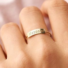 a woman's hand with a gold ring that says mason on it and a heart in the middle