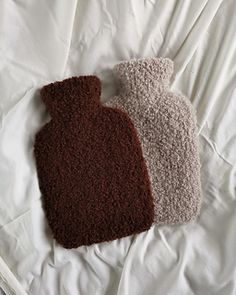 two brown and white items laying on top of a bed