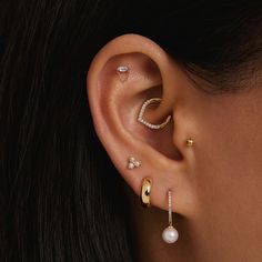 a close up of a person with ear piercings and pearls on their ears,