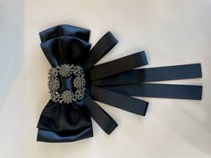 This beautiful black ribbon brooch has super bling glass beads. Rhinestones crystal bow brooch is a great way to elevate your blouse. Size: 6.3”wide 9.44” long The actual item's color maybe slightly different from the picture shown due to the lighting when the picture was shot. Gift idea Ribbon Brooch, Bow Brooch, Top Pants Set, Fascinator Hats, Jute Bags, Mens Scarves, Pin Jewelry, Black Ribbon, Organic Beauty