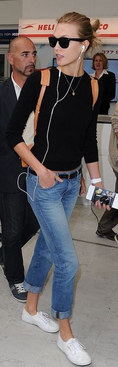 a woman in black shirt and jeans with headphones